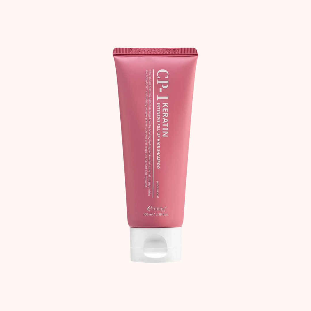 A pink squeeze tube of CP-1 Keratin Hair Shampoo with a white flip-top cap, centered on a solid off-white background.