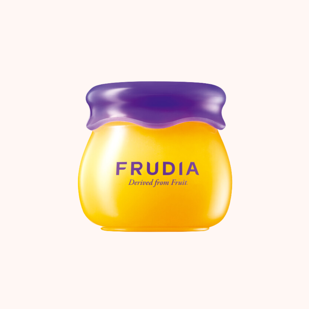 A jar of Frudia Blueberry Hydrating Honey Lip Balm with a purple lid, indicating the product is designed from fruit.
