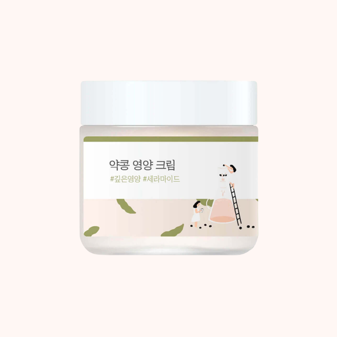 A cosmetic cream jar with a white lid and a white label featuring Korean text and a minimalist illustration of a person climbing a ladder next to a beaker. The label also has a thin olive green stripe and small green leaf shapes, set against a solid pale pink background.
