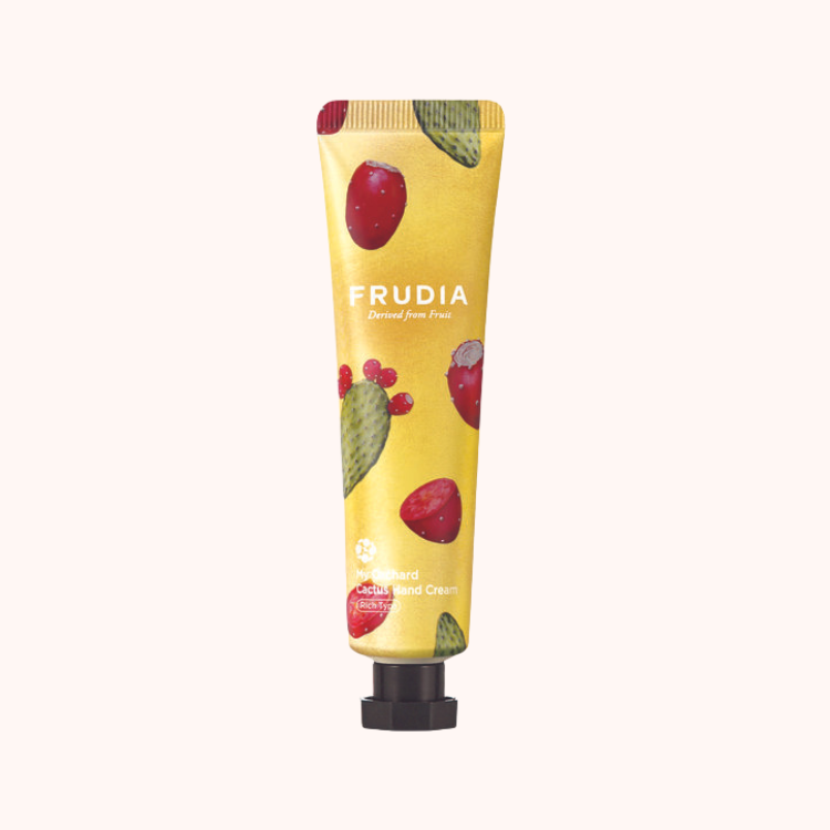 A tube of Frudia My Orchard Cactus Hand Cream with a yellow background and illustrations of red cactus fruits. The packaging displays the brand name and product information.