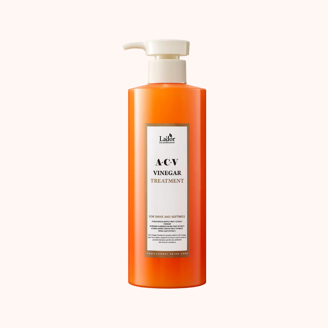 A bottle of Lador Professional Hair Care ACV Vinegar Treatment with a pump dispenser, primarily orange in color with a white label.