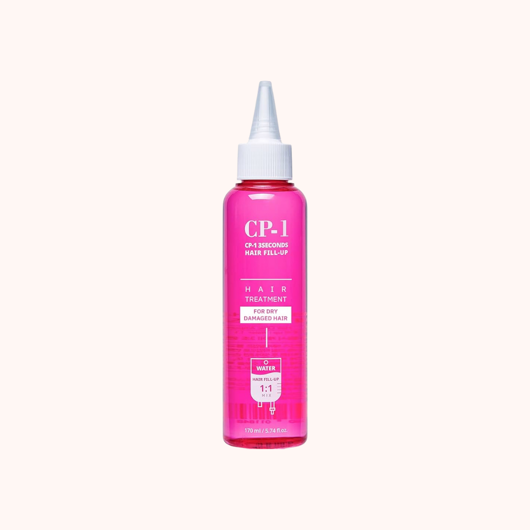 Pink hair treatment bottle with white cap on a white background