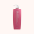 A pink pump bottle of Keratin Hair Shampoo with white text on the front, set against a solid pale pink background.
