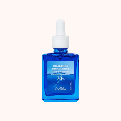 Dr. Alhakea Dilathia Aqua Marine Deep Serum in a square cobalt blue glass dropper bottle with a white cap, centered on a pale cream background.