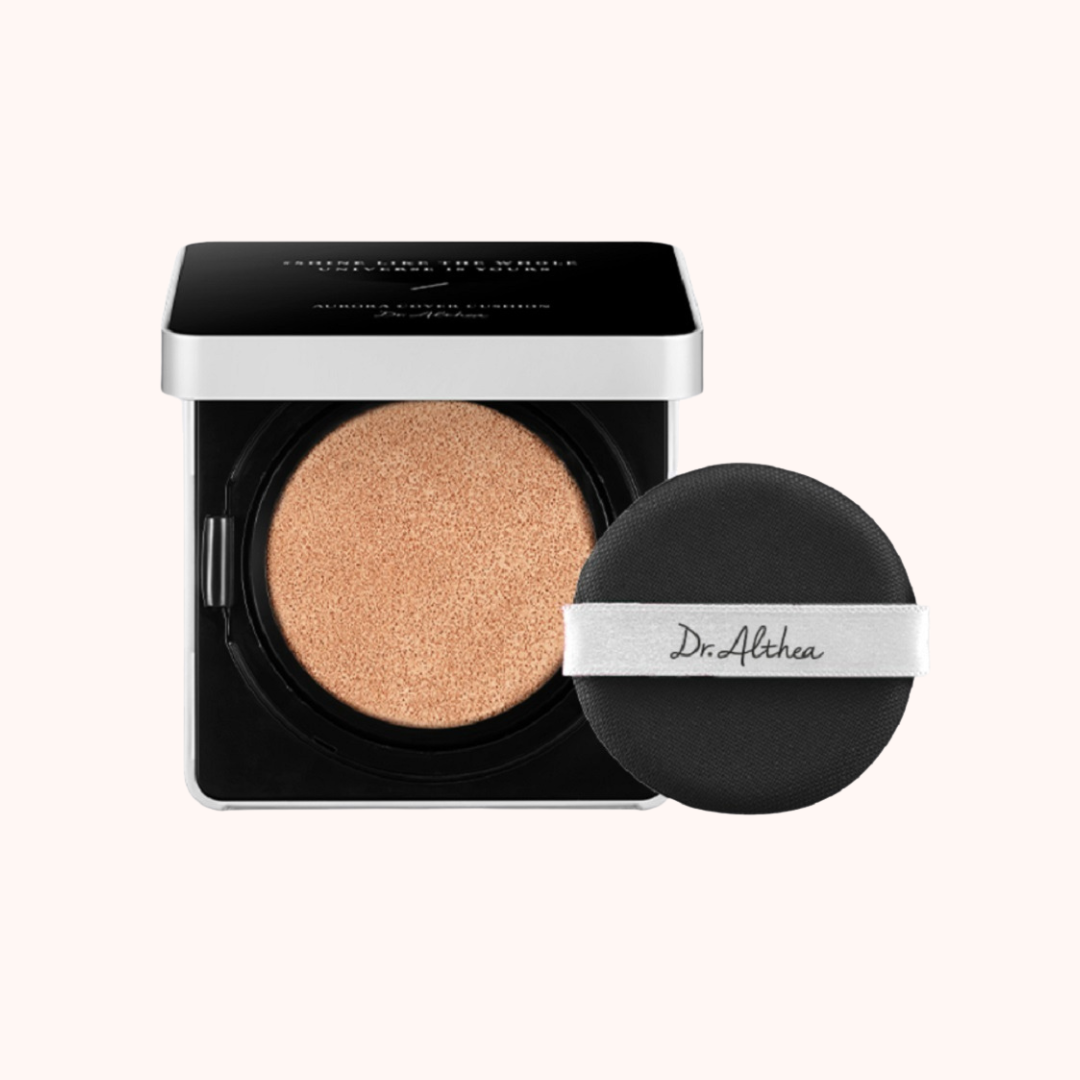 A palette of Dr. Althea Aurora Cover Cushion Moisture SPF 50+/PA+++ with a beige shade, alongside its black packaging and a matching cushion cover.