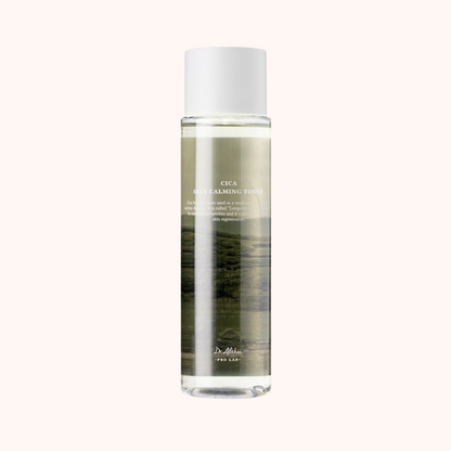 A clear glass bottle containing a light brown liquid with a label that reads &
