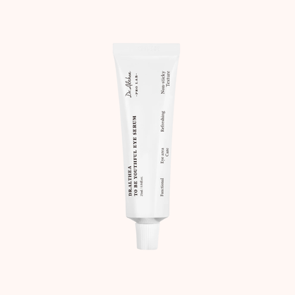 White skincare serum tube on a light beige background