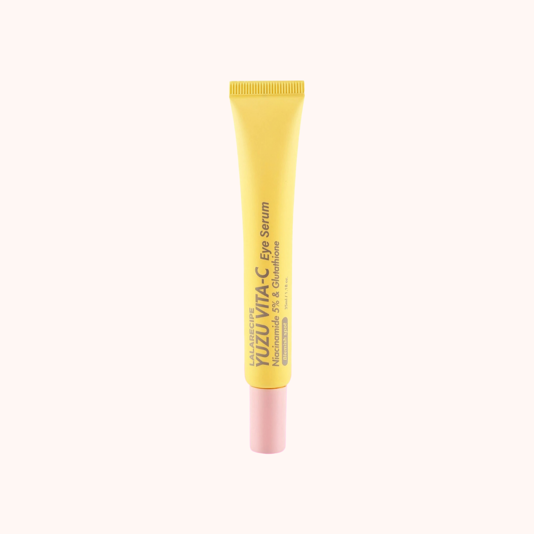 Yellow tube of eye serum with pink cap on a white background