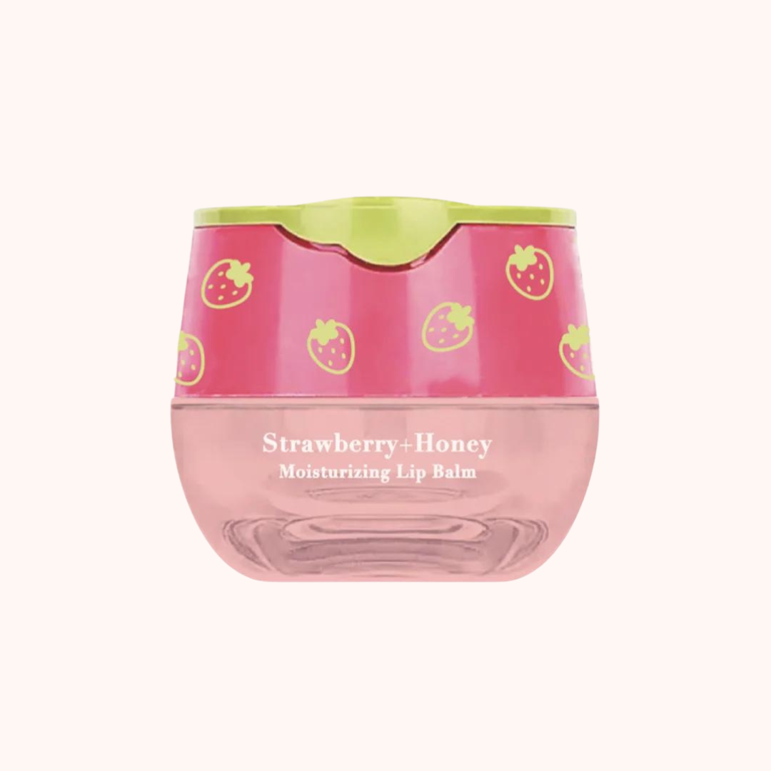 A pot of Look At Me Strawberry-Honey Moisturizing Lip Balm with a pink lid and strawberry print design.