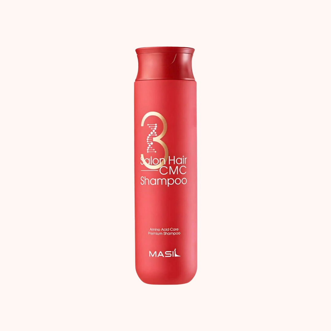 Red shampoo bottle with gold and white text on a white background