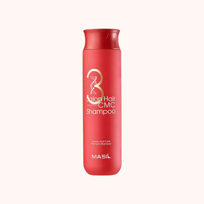 Red shampoo bottle with gold and white text on a white background