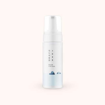 White skincare bottle with text and small graphics on a light gray background