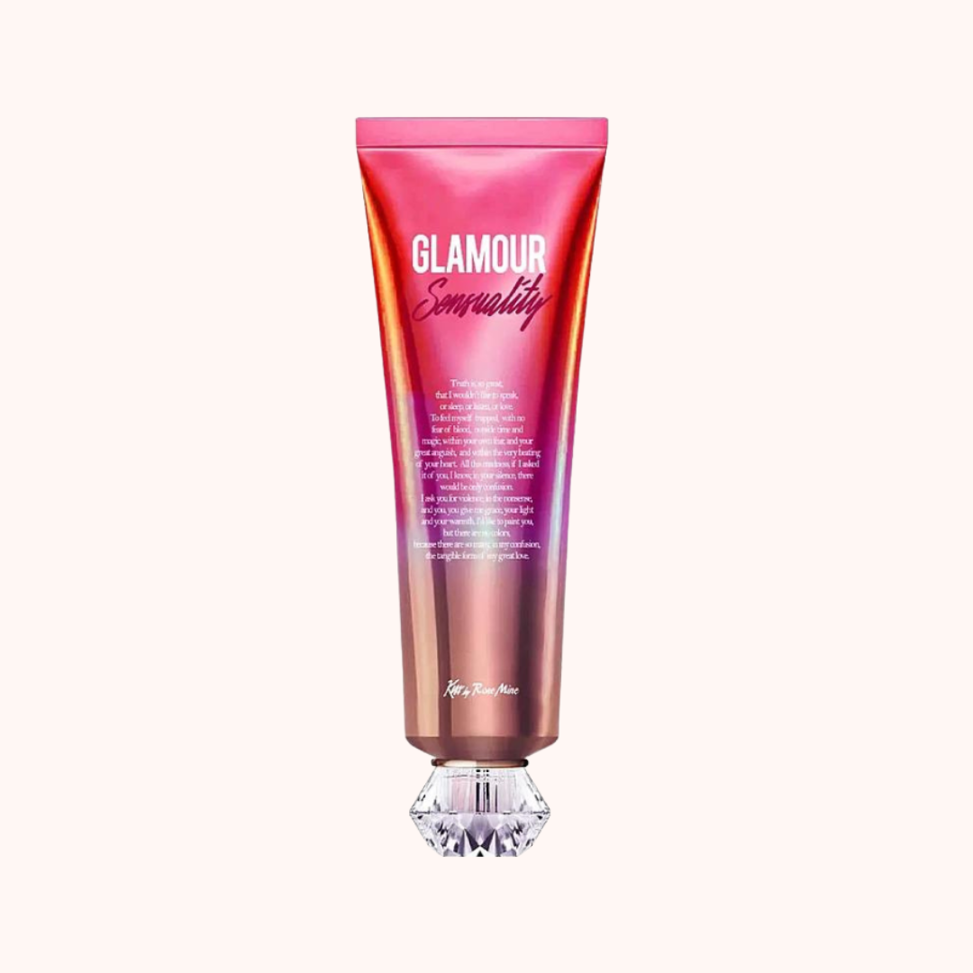 A tube of Kiss by Rosemine Fragrance Body Cream with a pink and orange design, featuring a clear crystal at the bottom.
